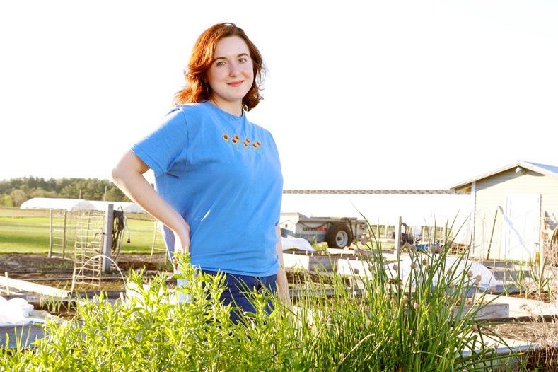 young woman standing in farm field